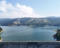 Vue panoramique du lac de la Liez, de sa digue et des collines boisées